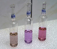 荧光灯下的钕化合物，从左到右分别为硫酸钕、硝酸钕和氯化钕。